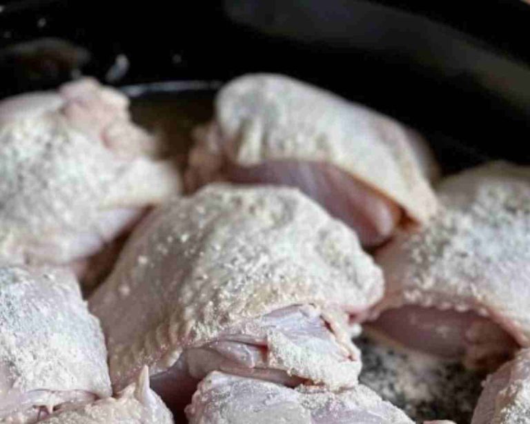 Coat chicken in flour and toss in slow cooker